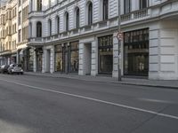 a narrow city street with tall buildings and traffic on both sides of it's pavement