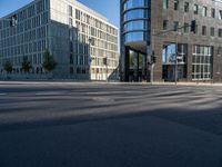 a cross walk next to a building on the side of a street with the reflection of a building on the ground