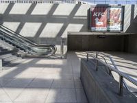 an escalator, stairs, and a street sign on a wall in a building