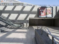 an escalator, stairs, and a street sign on a wall in a building