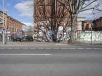 a motorcycle is parked on the side of the road beside a gate covered in graffiti