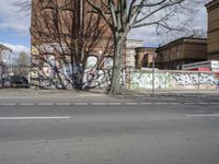 a motorcycle is parked on the side of the road beside a gate covered in graffiti