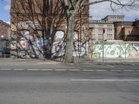 a motorcycle is parked on the side of the road beside a gate covered in graffiti