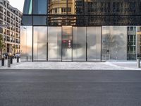 there are buildings and a traffic light in the reflection of glass doors of this building