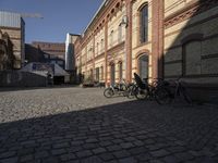 some bicycles parked on the street outside a building in an alleyway with other buildings