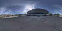 an empty parking lot with a sky in the background and a circular design on the pavement