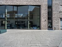 a person sitting on a bench with a book on it's side looking out at the buildings