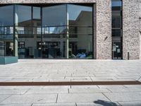 a person sitting on a bench with a book on it's side looking out at the buildings