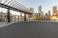 a view of a city and its skyline at dusk from an enclosed walkway overlooking a parking lot