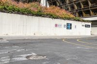 a large white wall next to a road with traffic signs on it that read no parking