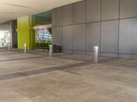 a picture of a building with green walls and columns and concrete flooring, as well as a gray pillar on the right