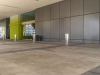 a picture of a building with green walls and columns and concrete flooring, as well as a gray pillar on the right