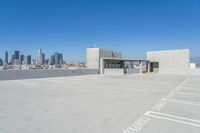 the view of a parking lot with some buildings in the background and a blue sky