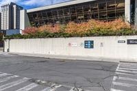 a road sign pointing to the right near a street with multiple parking spaces in the background