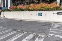 a road sign pointing to the right near a street with multiple parking spaces in the background