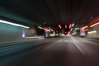 a blurry picture of a dark street with the light from cars in motion, in the middle of the night