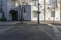 a couple walk past the entrance to a building that has a parking meter sitting next to it