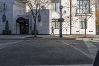 a couple walk past the entrance to a building that has a parking meter sitting next to it