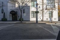 a couple walk past the entrance to a building that has a parking meter sitting next to it