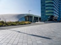 large modern glass building sitting across the street from the curved glass wall of an office