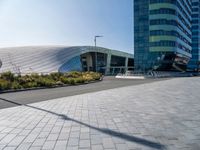 large modern glass building sitting across the street from the curved glass wall of an office