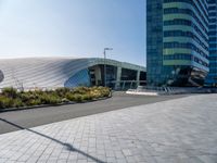 large modern glass building sitting across the street from the curved glass wall of an office