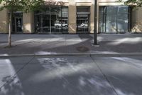 a sidewalk on the corner of an office building and storefront and sidewalk and sidewalk