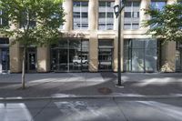 a sidewalk on the corner of an office building and storefront and sidewalk and sidewalk