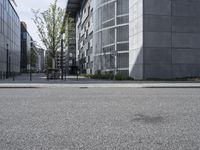 an empty sidewalk in front of buildings and a bench on the side of the street