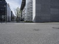 an empty sidewalk in front of buildings and a bench on the side of the street