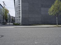 an empty sidewalk in front of buildings and a bench on the side of the street