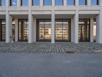 the large office building is located in the center of a cobblestone plaza of the city