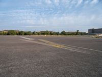 an empty runway with no people in it but a few buildings around the plane line