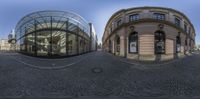 a reflection of a building on a mirror outside the museum entrance, with it's circular entrance at the center and other angles and sides