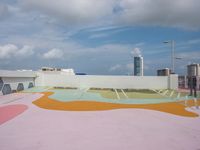 colorful concrete wall painted in the shape of a flower is in an outdoor area of a modern building