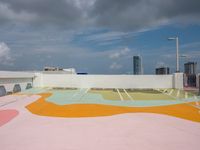 colorful concrete wall painted in the shape of a flower is in an outdoor area of a modern building