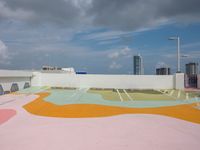 colorful concrete wall painted in the shape of a flower is in an outdoor area of a modern building