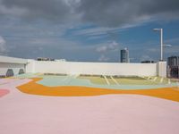 colorful concrete wall painted in the shape of a flower is in an outdoor area of a modern building