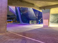 the large square in front of a building that has an open entry way on one side and a purple entrance on the other