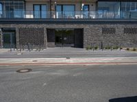 a building has a balcony next to it on the side of a street and next to the sidewalk