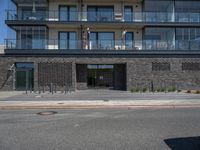 a building has a balcony next to it on the side of a street and next to the sidewalk