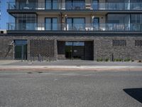 a building has a balcony next to it on the side of a street and next to the sidewalk