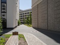 a wooden bench sitting in the middle of a courtyard area next to buildings in the background