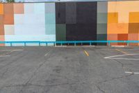 a colorful building painted in bright colors on the wall and concrete flooring around it