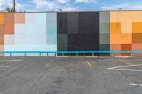 a colorful building painted in bright colors on the wall and concrete flooring around it