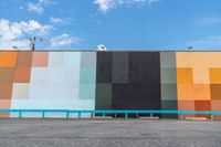 a colorful building painted in bright colors on the wall and concrete flooring around it