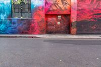 a fire hydrant on the side of a road with red graffiti painted all over it