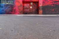 a fire hydrant on the side of a road with red graffiti painted all over it