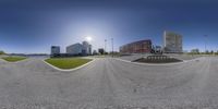 a wide angle shot with buildings in the background and the sun shining above the building