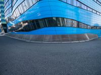 a man holding a frisbee standing on a road near a building that looks very futuristic